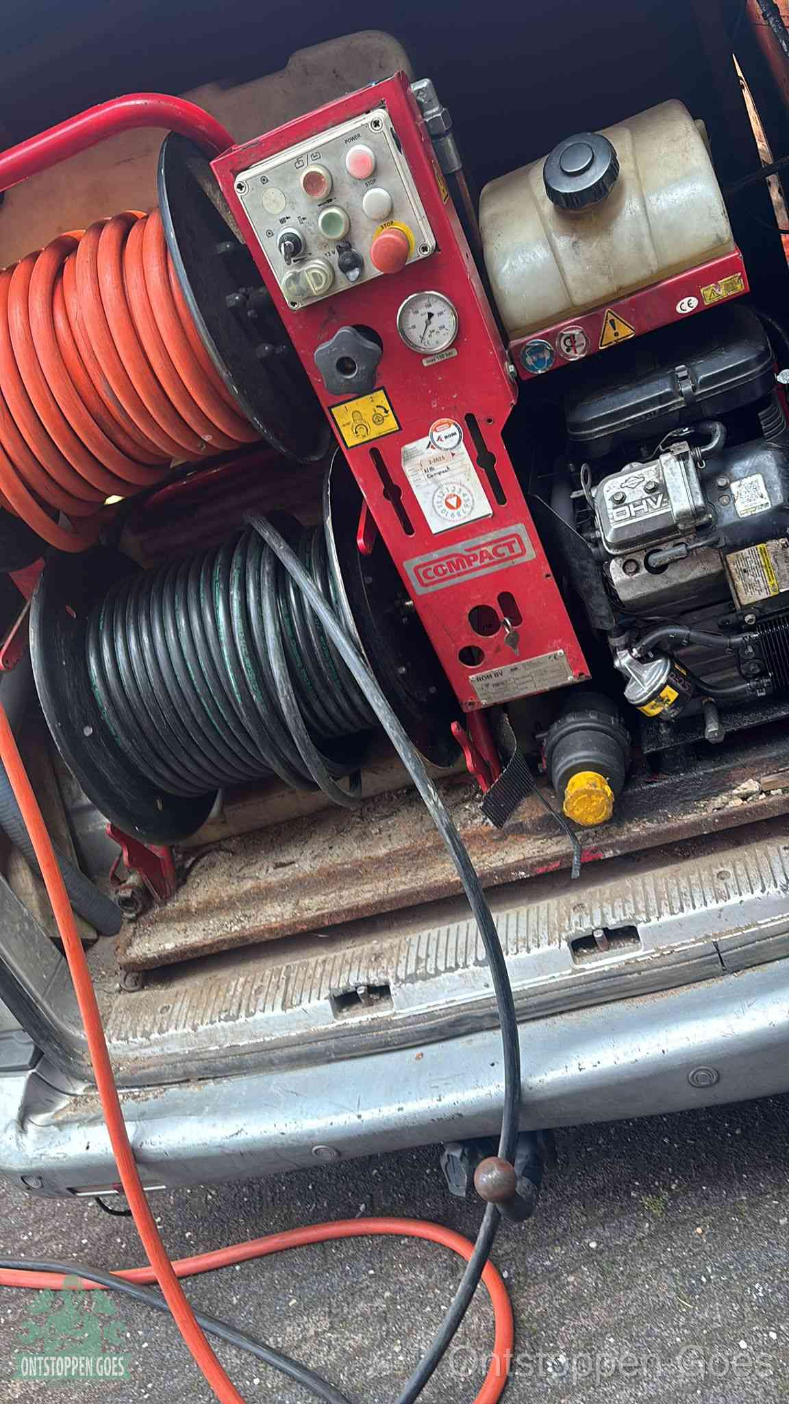 Een rood hogedruk-rioolreinigingstoestel in de laadbak van de bedrijfsbus, apparatuur voor een hardnekkige afvoerverstopping in Goes