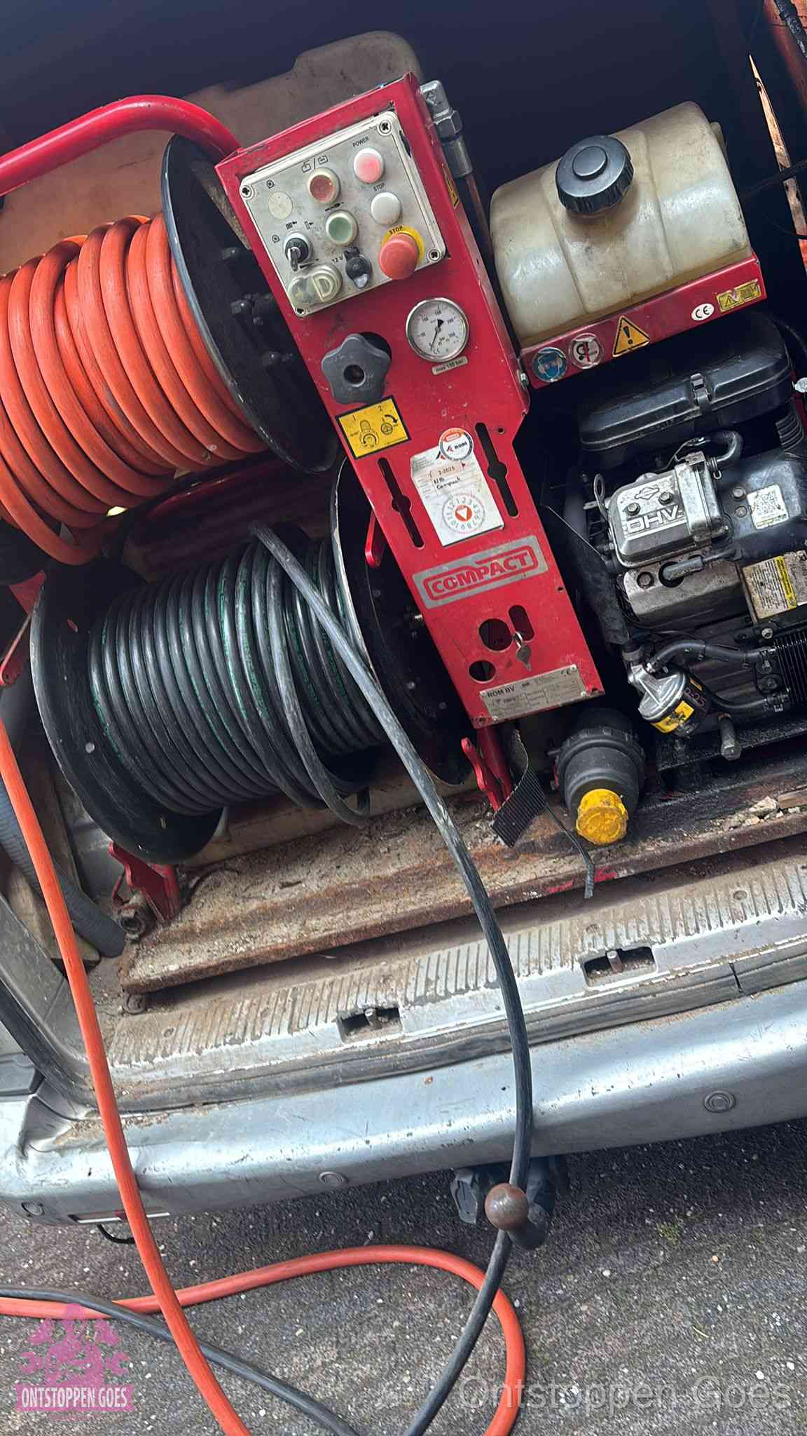 Een rood hogedruk-rioolreinigingstoestel met slangen in de laadbak van de bedrijfsbus, apparatuur voor een hardnekkige wc-verstopping in Goes