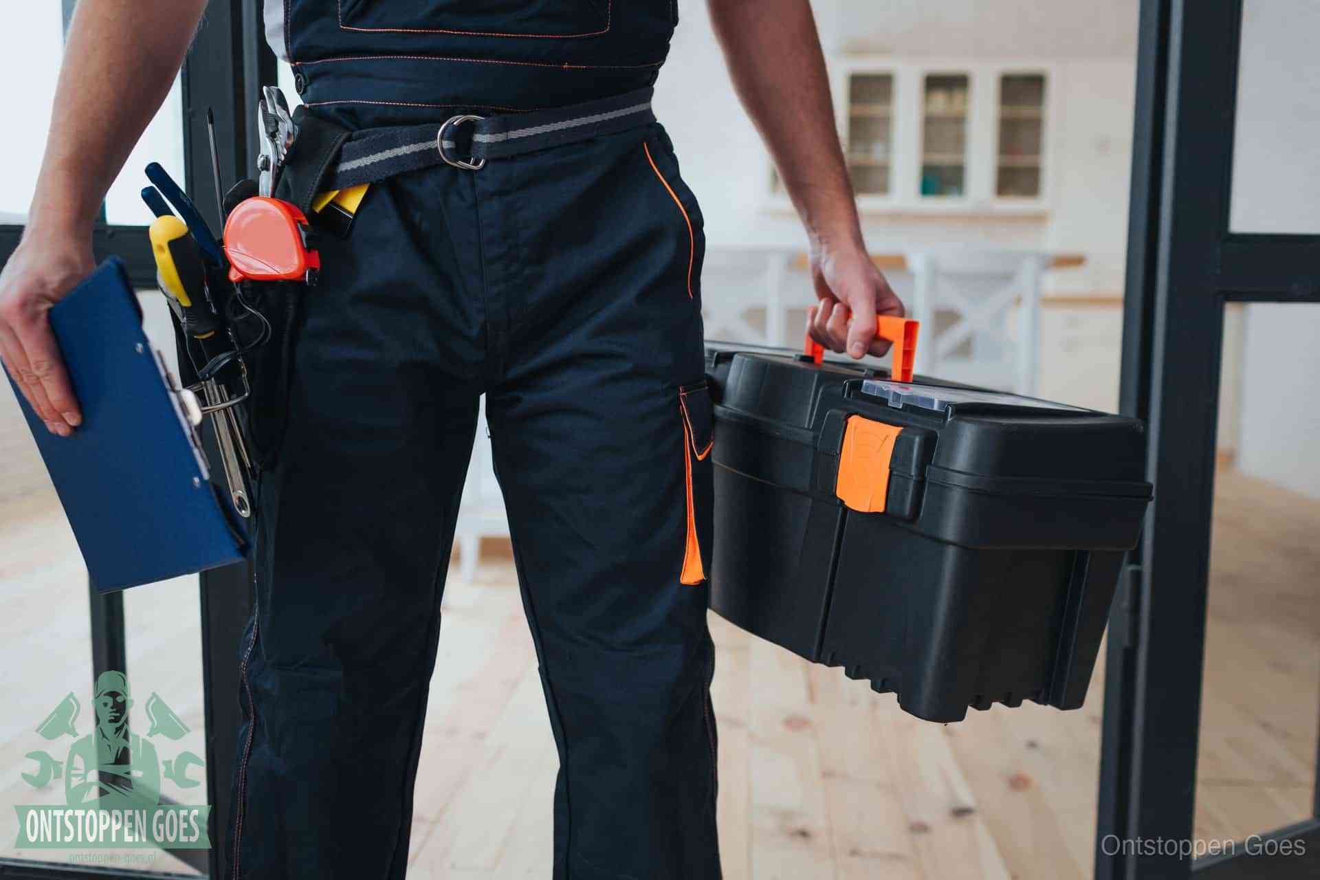 Een monteur met gereedschapsriem en klembord, klaar om een transparante prijs voor het afvoer ontstoppen in Goes te geven
