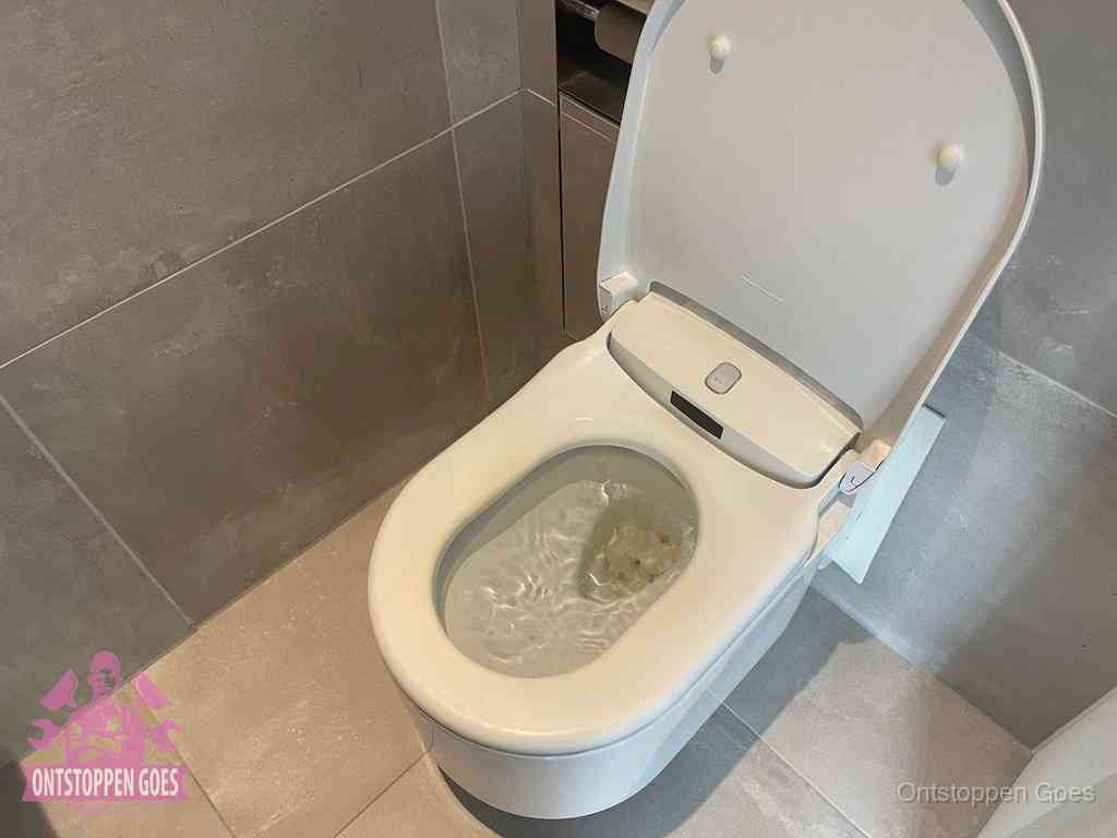 Een toiletpot vol troebel water met drijvend papier en restanten, de meest voorkomende oorzaak van een verstopte wc in Goes